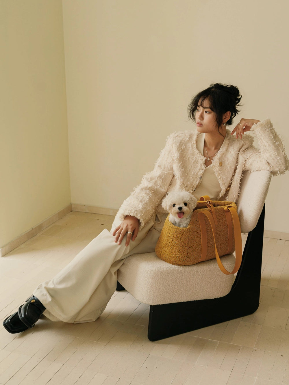 woman-sitting-on-chair-with-kamamuta-mini-tweed-tote-bag-and-small-white-dog-in-warm-indoor-setting