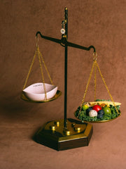 vintage-brown-balance-scale-with-pink-kamamuta-pet-pod-bowl-on-one-side-and-fruits-vegetables-on-other-side
