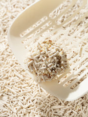 close-up-of-kamamuta-tofu-cat-litter-clumping-held-by-scoop-with-litter-background