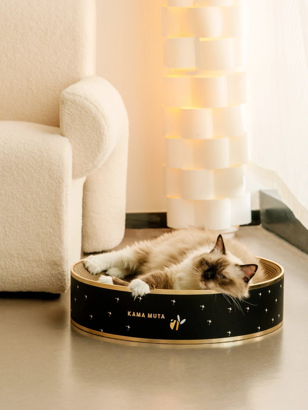 cat-sleepily-closing-eyes-in-kamamuta-cat-scratcher-bed-with-cozy-indoor-home-background