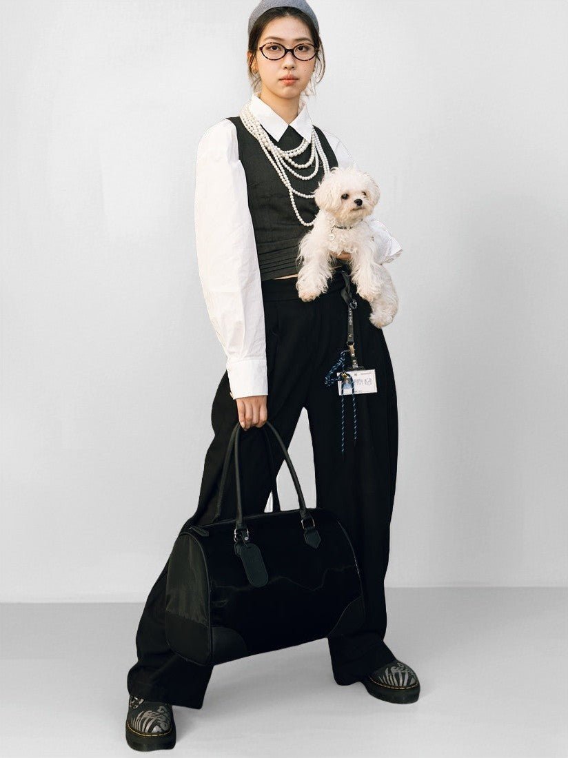fashion-woman-holding-white-maltese-in-left-arm-carrying-kamamuta-black-boston-pet-bag-in-right-hand