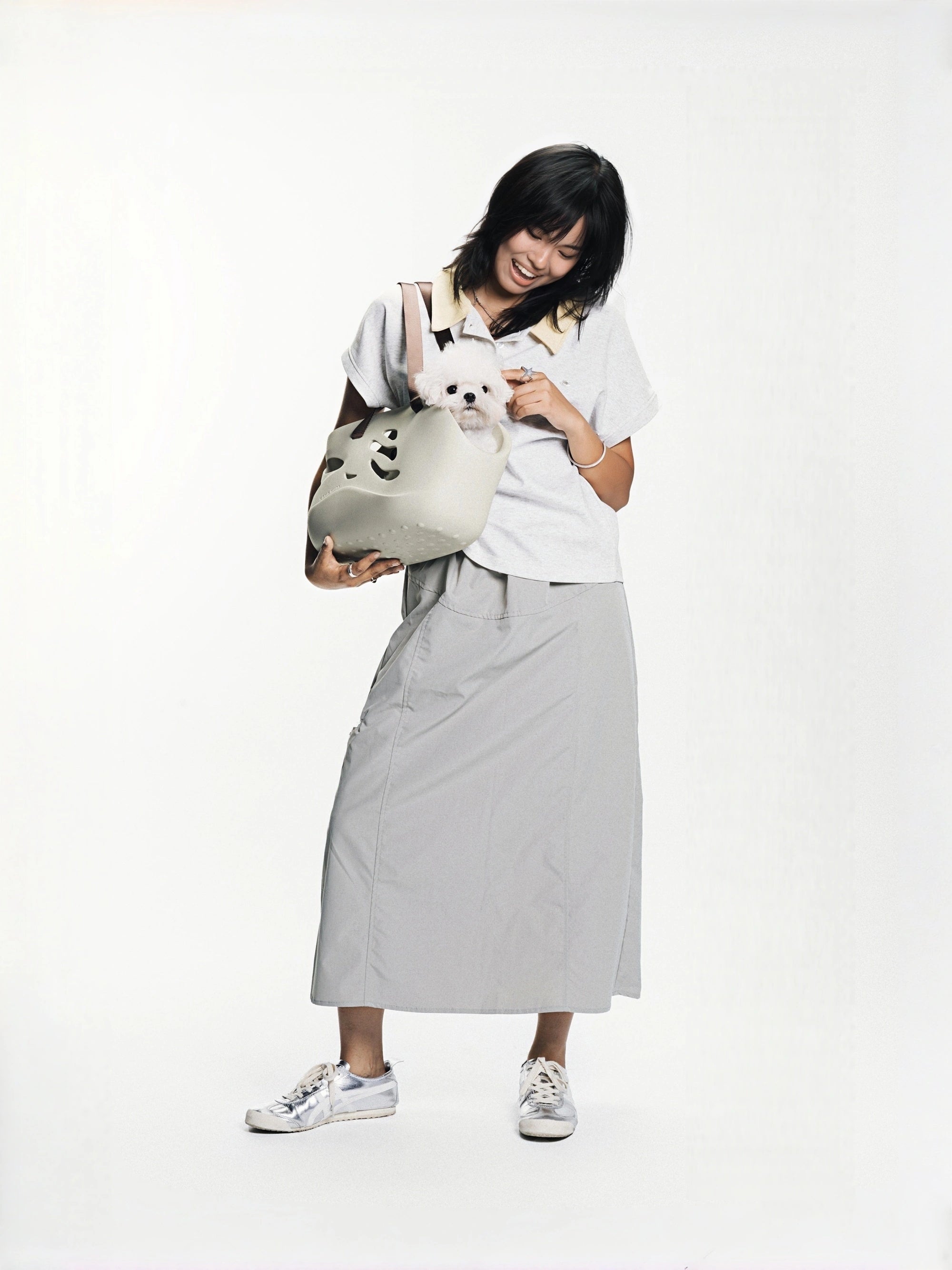 woman-holding-maltese-dog-in-kamamuta-wave-pet-tote-carrier-against-white-background
